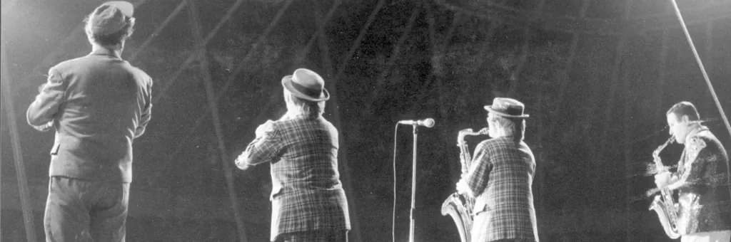 Avant restauration : musiciens et saxophonistes sur scène, photo ancienne en noir et blanc