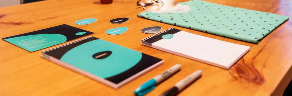 Identité visuelle turquoise déclinée sur carnets, papeterie et stylos