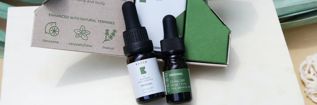 Bandeau packaging : flacons compte-gouttes d’huiles essentielles et leur étui vert