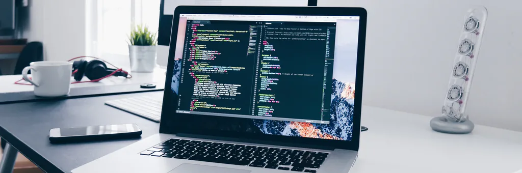 Bandeau site web : ordinateur portable affichant du code sur un bureau blanc