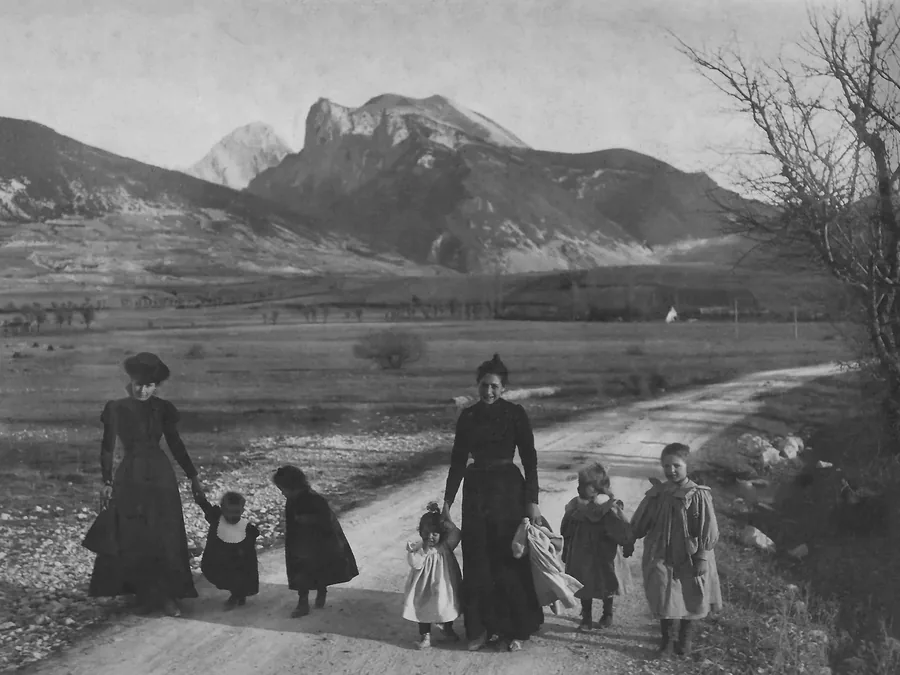 Après restauration : famille en promenade sur un chemin de montagne, photo ancienne en noir et blanc