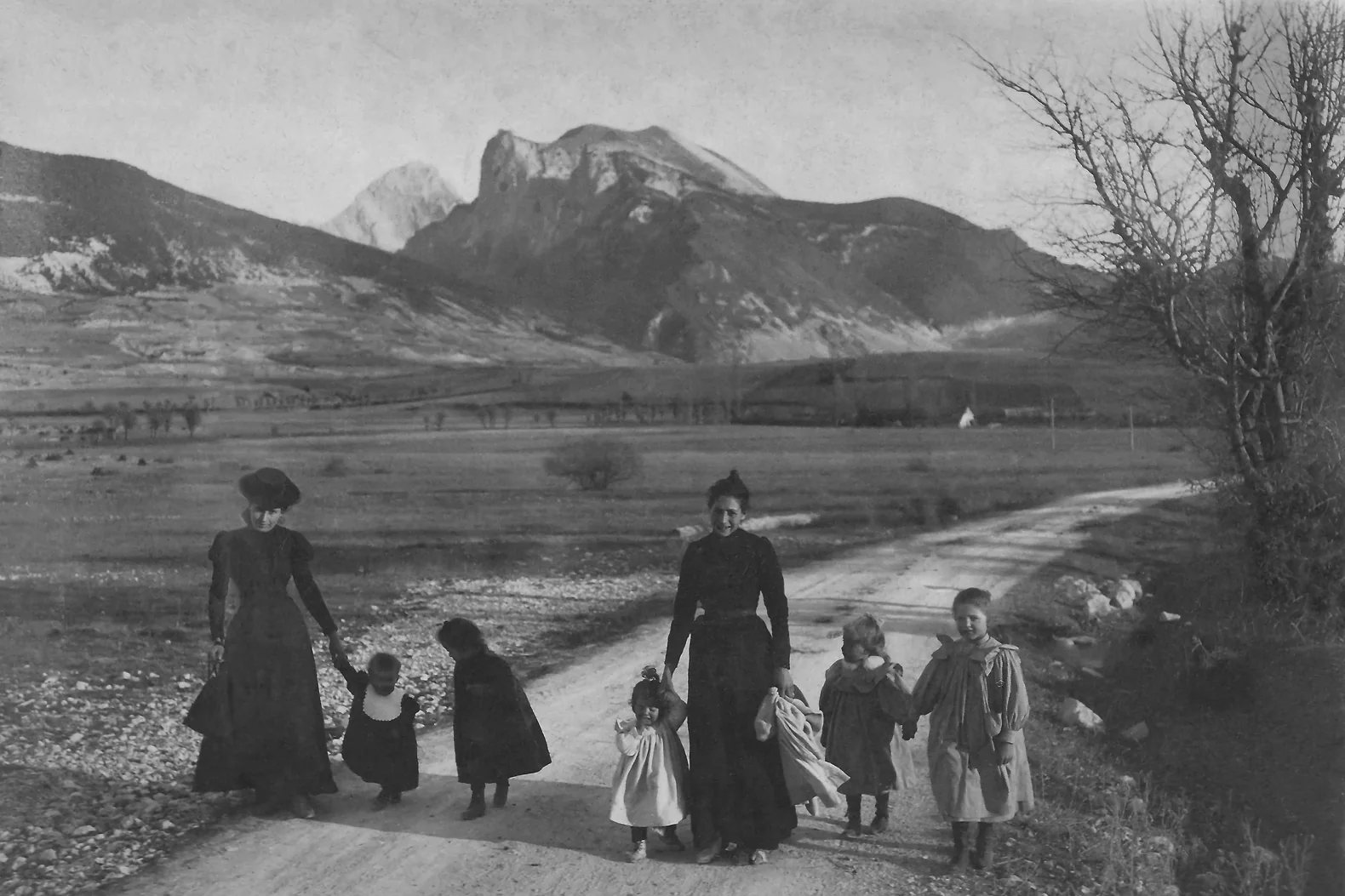 Après restauration : famille en promenade sur un chemin de montagne, photo ancienne en noir et blanc