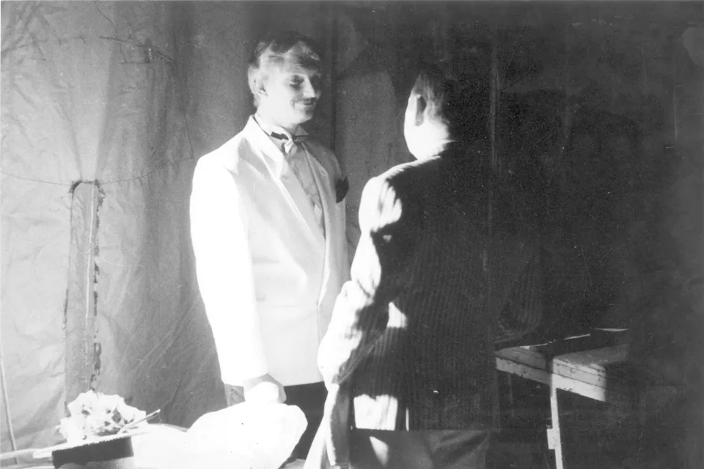 Avant restauration : deux hommes, dont l’un en veste blanche, photo ancienne tachée