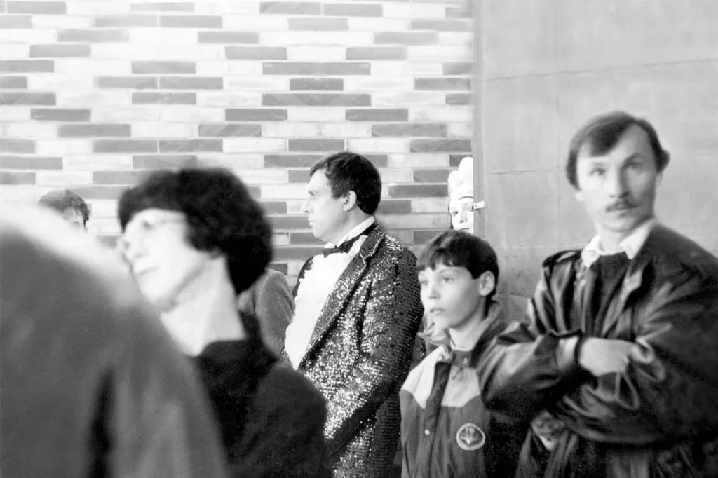Après restauration : groupe de personnes et homme en veste à paillettes, photo des années 1980
