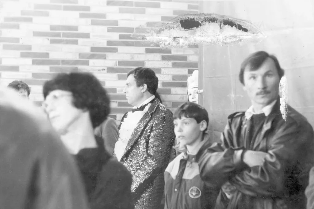 Avant restauration : groupe de personnes et homme en veste à paillettes, photo des années 1980